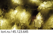 Transparent skeletons glowing yellow, close-up. Transform your space with a whimsical garland featuring glowing skeleton skulls and bones, perfect for Halloween festivities and ambiance. Horror theme. Стоковое видео, видеограф Юлия Петровская / Фотобанк Лори
