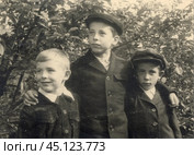 Три мальчика в школьной форме на фоне живой изгороди в 1940-е годы. Стоковое фото, фотограф Retro / Фотобанк Лори