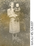 Женщина с маленьким мальчиком на руках в 1950-е годы. Стоковое фото, фотограф Retro / Фотобанк Лори