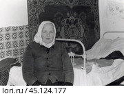 Старушка в платке на фоне кровати и ковра на стене, СССР. Стоковое фото, фотограф Retro / Фотобанк Лори