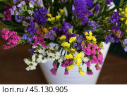 Bouquet of multicolored flowers in a vase (Limonium sinuatum, Statice sinuata) on a green background. Стоковое фото, фотограф Ирина Вершинская / Фотобанк Лори