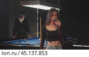 Portrait of a beautiful girl preparing to play billiards with her friend. Стоковое видео, видеограф Strunov David / Фотобанк Лори