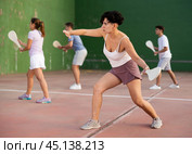 Portrait of sporty girl playing paleta fronton on outdoor court, ready to hit ball. Healthy and active lifestyle concept. Стоковое фото, фотограф Яков Филимонов / Фотобанк Лори