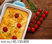 appetizing golden focaccia with tomatoes and spices, on dark wooden rustic table. Стоковое фото, фотограф Natalia Gdovskaia / Фотобанк Лори