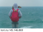 Девочка-путешественница смотрит на море перед грозой. Стоковое фото, фотограф YuryKara / Фотобанк Лори