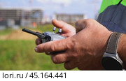a surveyor on a construction site controls a quadcopter. Стоковое видео, видеограф Igor Skripachev / Фотобанк Лори
