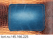 Blank jeans frame. Denim patch with orange thread seam on brown skin. Стоковое фото, фотограф Александр Собко / Фотобанк Лори