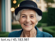Sophisticated smiling older French woman in the open air. Demeanor reveals a lifetime of experiences and reflections, embodying grace and wisdom. Well-groomed woman 70 years old with grey hair. AI. Стоковое AI-изображение, AI-художник Юлия Петровская / Фотобанк Лори