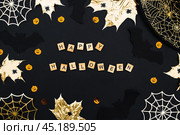 The inscription happy Halloween. Modern background with black bats, Golden leaves, cobwebs and wooden letters. Halloween with copy space for text. Flat lay, top. Стоковое фото, фотограф Photojuli / Фотобанк Лори