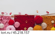 Video of colorful woolen balls and wool yarn for hand knitting, accessories and three samples for knitting scarf on knitting needles. Knit as a hobby. Top view, close-up, flat lay, mock up. Стоковое видео, видеограф Виктория Катьянова / Фотобанк Лори