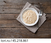 Large bowl of tasty and healthy oatmeal for Breakfast, morning meal. Top view, close up, wooden rustic table. Стоковое фото, фотограф Natalia Gdovskaia / Фотобанк Лори