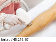 Elos epilation hair removal procedure on a woman body. Beautician doing laser rejuvenation in a beauty salon. Removing unwanted body hair. Hardware ipl cosmetology. Стоковое фото, фотограф Ирина Михайличенко / Фотобанк Лори