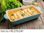 Cannelloni with filling of ground beef, tomatoes, baked with bechamel tomato sauce, side view, old dark wooden background. Стоковое фото, фотограф Natalia Gdovskaia / Фотобанк Лори