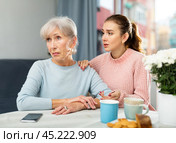 Young woman trying to apologize to offended mother at home. Стоковое фото, фотограф Яков Филимонов / Фотобанк Лори
