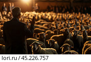 A speaker makes a presentation in a conference room among a flock of sheep. The concept of trust. Стоковое AI-изображение, AI-художник Ярославский Максим / Фотобанк Лори
