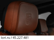 Rostov-on-Don, Russia - October 7, 2024: Porsche logo on brown headrest. Редакционное фото, фотограф Владислав Тригуб / Фотобанк Лори