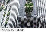 Skyscraper in Singapore blends ultramodern design with lush greenery adorning facade, seamless integration of contemporary architecture and nature. urban sophistication and ecological beauty. Стоковое фото, фотограф Павел Муравьев / Фотобанк Лори