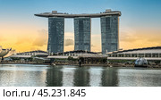 Singapore, 24 January 2024: Marina Bay Sands, iconic symbol of Singapore, dominates skyline of Marina Bay. hotel three towers connected by unique rooftop, featuring stunning infinity pool. Редакционное фото, фотограф Павел Муравьев / Фотобанк Лори