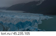 The amazing Perito Moreno Glacier. A mass of blue ice with cracks, crevices, and sharp peaks stretches between the mountains. Thawed ice floes float in a glacial lake. Fog. El Calafate. Argentina. (2023 год). Стоковое фото, фотограф Вера Ивановна Кубарева / Фотобанк Лори