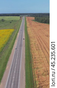 Vertical aerial video of buckwheat and sunflower fields along chuysky tract road in Altai region. Drone moves sideways. Стоковое видео, видеограф Сергей Пристяжнюк (Serg Zastavkin) / Фотобанк Лори