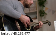 Playing the guitar. Strumming black acoustic guitar. Musician plays music. Man fingers holding mediator. Male hand playing guitar neck in dark room. Unrecognizable person rehearsing, fretboard closeup. Стоковое видео, видеограф Марина Демидюк / Фотобанк Лори