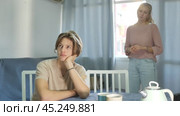 Sad woman after discord with her teen son sitting at kitchen indoors, home conflict. Стоковое видео, видеограф Яков Филимонов / Фотобанк Лори