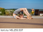 Fitness portrait young athletic woman doing gymnastics on blue sky background. Стоковое фото, фотограф Андрей Аркуша / Фотобанк Лори