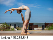 A young woman in a tracksuit performs physical exercises in a summer park. Стоковое фото, фотограф Андрей Аркуша / Фотобанк Лори