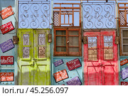 Rustic doors with intricate metal grilles and Arabic signs form vibrant decor. Egypt (2024 год). Редакционное фото, фотограф Ирина Кононова / Фотобанк Лори