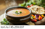 Steaming hot gazpacho soup with pita bread and fresh vegetables. Стоковое AI-изображение, AI-художник Юрий Поздников / Фотобанк Лори