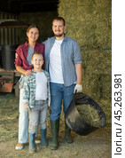 Portrait of happy family with son in backyard of horse farm, with hay in background. Стоковое фото, фотограф Яков Филимонов / Фотобанк Лори