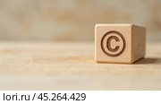 Wooden block with copyright symbol on wooden surface, close-up. intellectual property, legal protection, and copyright law. articles, blogs, and educational materials on copyright. Стоковое фото, фотограф Павел Муравьев / Фотобанк Лори