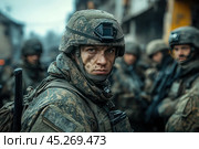 Young soldier in military uniform and helmet, with serious and concentrated expression. His face is dirty, which emphasizes the tension and severity of the situation. In the background, other soldiers are visible, blurred, creating focus on the main character. The photo is made in cold tones, conveying the atmosphere of combat or preparation for a mission. The soldier's expression and the details of the uniform enhance the feeling of realism and survival in difficult conditions. Стоковое AI-изображение, AI-художник Анна Кривицкая / Фотобанк Лори