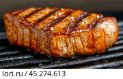 Grilled steak with perfect sear marks and a sprinkle of salt on a hot grill, AI. Стоковое AI-изображение, AI-художник Сергей Старуш / Фотобанк Лори