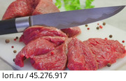 A damask steel knife with a pattern cuts red meat. Chopped beef, slices, abolition of vegetarianism, semi-finished meat products, soy meat. Стоковое видео, видеограф Елизавета Малкова / Фотобанк Лори