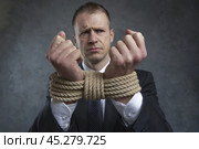 Sad businessman man with his hands tied with rope. Focus on the rope. Стоковое AI-изображение, AI-художник Дмитрий Киселёв / Фотобанк Лори