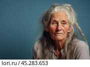Unamused sad miserable mature long grey haired caucasian woman wearing grey blouse, frowns face with dissatisfaction, sulks troubled as someone hurt her feelings. Indoor studio shot isolated on blue. Стоковое AI-изображение, AI-художник Sergey Grishin / Фотобанк Лори