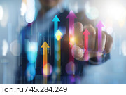 Increased profits. Benchmarking. Businessman analyzes profitability of working companies with digital augmented reality graphics, positive indicators, growing up graph and charts, colorful arrows. Стоковое AI-изображение, AI-художник Марина Демидюк / Фотобанк Лори