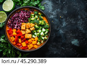 Colorful fresh salad ingredients arranged in a bowl with lime and herbs on a dark surface. Стоковое AI-изображение, AI-художник Юлия Гапеенко / Фотобанк Лори