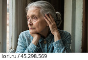 Woman of age, peers through window, hands resting on face, engrossed in memories and reflections. Atmosphere is quiet, introspective. Стоковое AI-изображение, AI-художник Павел Муравьев / Фотобанк Лори