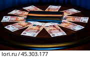 Деньги. Купюры достоинством 5000 рублей лежат веером возле кошелька на небольшом круглом столике. Стоковое фото, фотограф Владимир Устенко / Фотобанк Лори