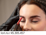 The cosmetologist creates the perfect eyebrow contour for tattooing. Стоковое фото, фотограф Юрий Поздников / Фотобанк Лори
