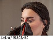 Beautician drawing eyebrow shape on woman's face for microblading treatment. Стоковое фото, фотограф Юрий Поздников / Фотобанк Лори
