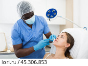 Woman receiving injections for lip augmentation at cosmetology clinic. Стоковое фото, фотограф Яков Филимонов / Фотобанк Лори