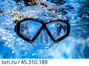 Diving mask submerged in blue water with bubbles around. Стоковое AI-изображение, AI-художник Иван Рябоконь / Фотобанк Лори