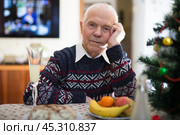 Portrait of tired lonely elderly man at the dinner table during christmas celebration. Стоковое фото, фотограф Татьяна Яцевич / Фотобанк Лори