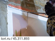 Installation of a matte interior window, foaming the gaps with polyurethane foam. Construction and repair. Стоковое фото, фотограф Коханова Наталья / Фотобанк Лори