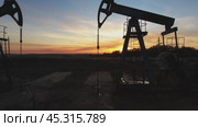 Flying near working oil pumps at sunset. Стоковое видео, видеограф Михаил Коханчиков / Фотобанк Лори