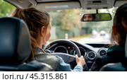 Aspiring young woman conquers the road: learning to drive with confidence. Стоковое AI-изображение, AI-художник Сергей Бирюков / Фотобанк Лори