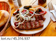 Turkish lula mutton kebab with onion and vegetables on table. Стоковое фото, фотограф Яков Филимонов / Фотобанк Лори